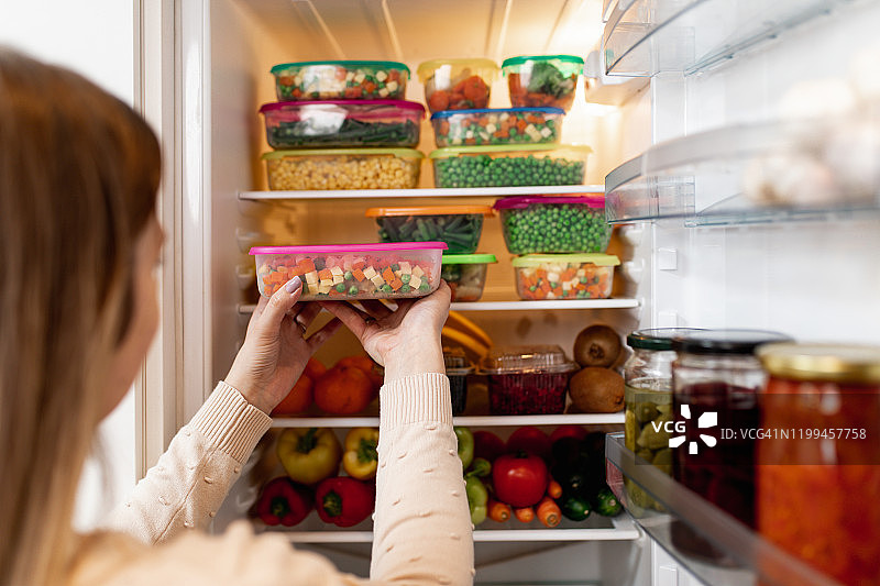 女人从冰箱里拿取生食图片素材
