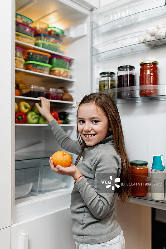 女孩从冰箱里拿生食图片素材