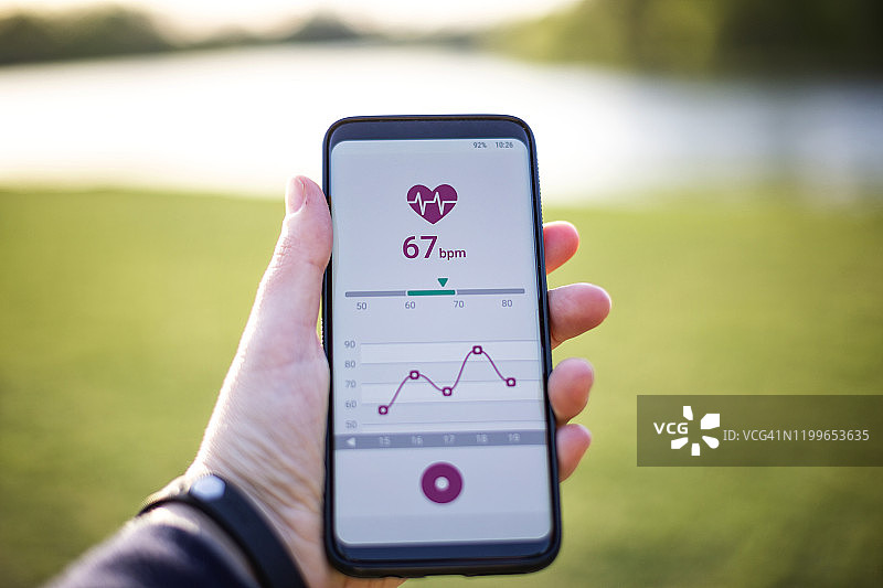 女人手持智能手机使用健身App图片素材