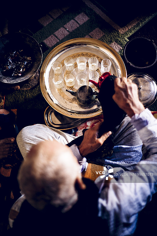 在阿尔及利亚廷杜夫斯马拉难民营准备茶的年长男人图片素材