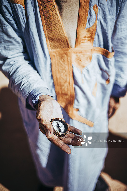 在阿尔及利亚廷杜夫斯马拉难民营中手持指南针的年长男人特写图片素材