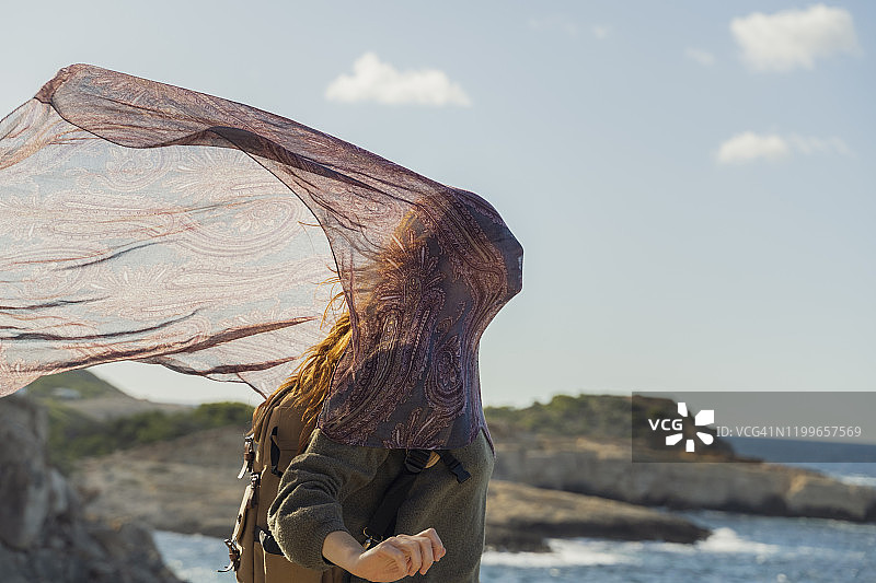 西班牙伊维萨岛，海边脸部裹着布的年轻女子图片素材