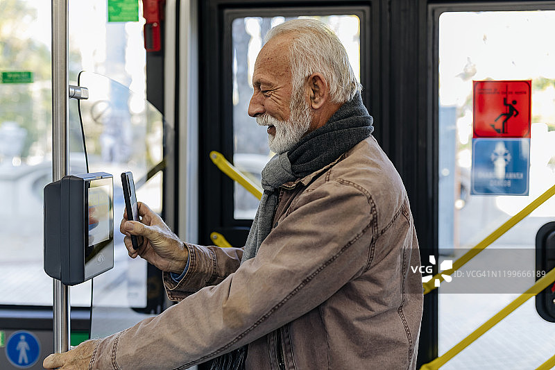 男人用手机支付公交车票图片素材