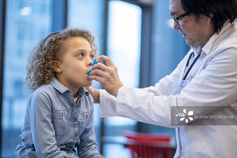 医生给小女孩哮喘吸入器图片素材