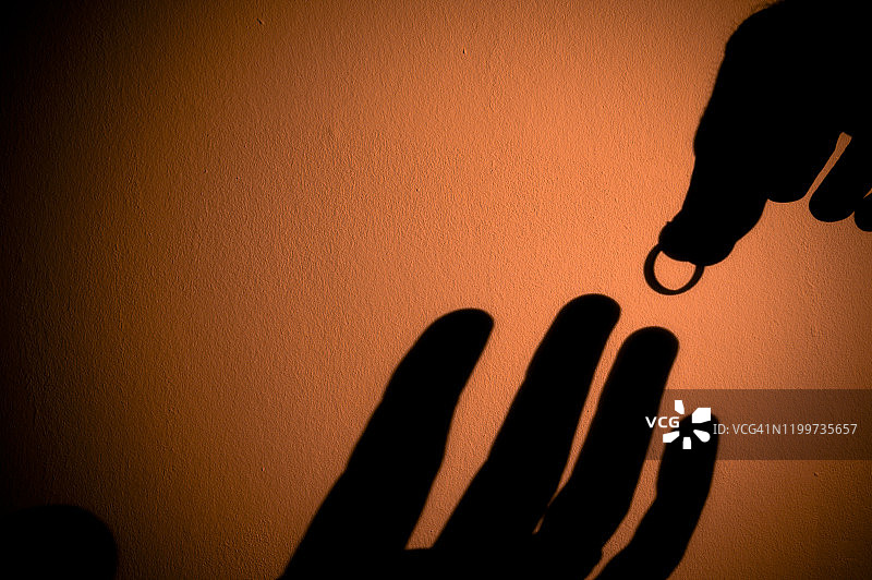 手持订婚戒指的轮廓，准备戴在爱人手上图片素材