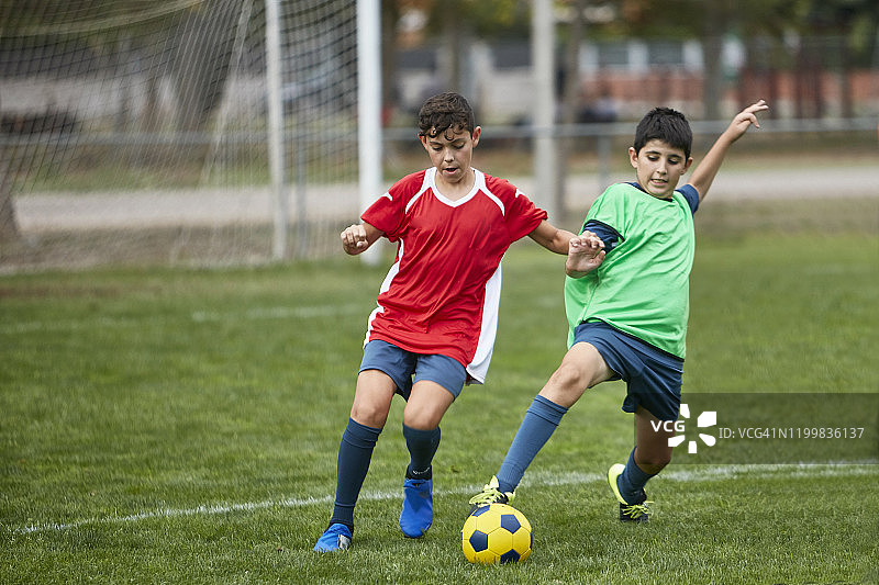 在球场上争球的年轻西班牙男足球员图片素材