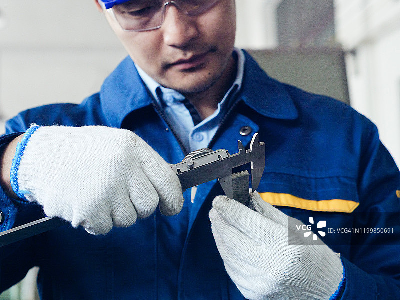 工程师使用卡尺进行质量控制图片素材