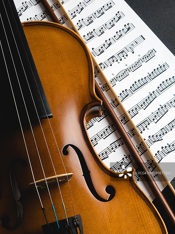 黑色背景和乐谱上的小提琴图片素材