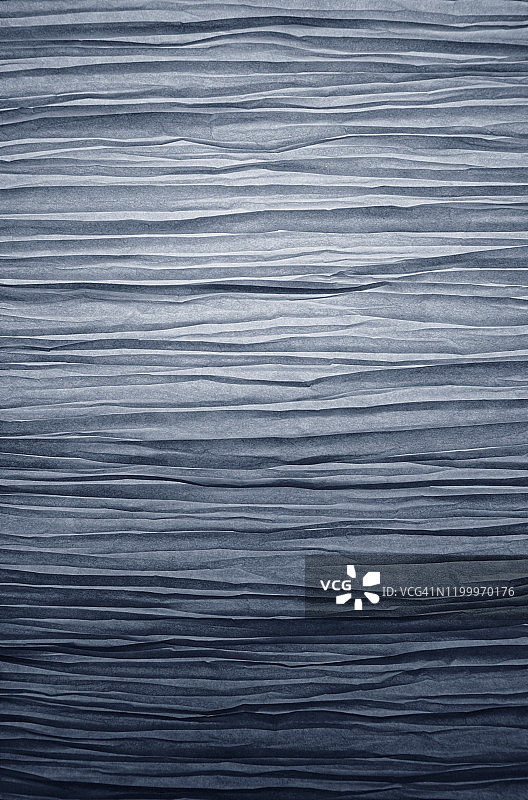 蓝色折叠纸质灯罩背光特写。图片素材