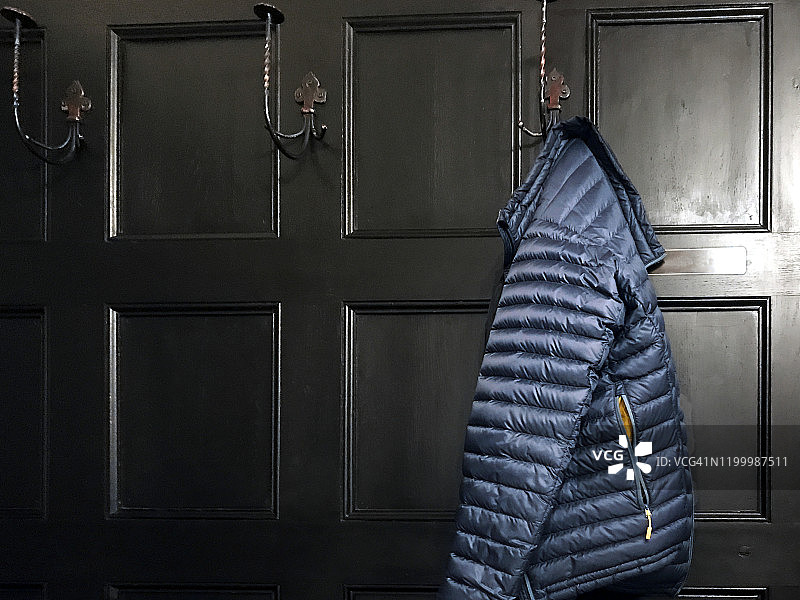 挂在木墙上的亮蓝色外套静物图片素材