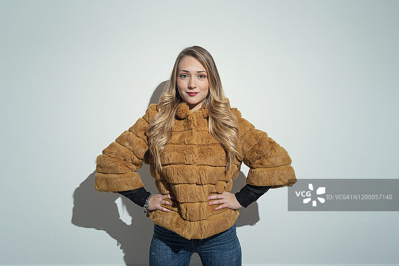 身穿黄色皮草外套的金发年轻女人图片素材