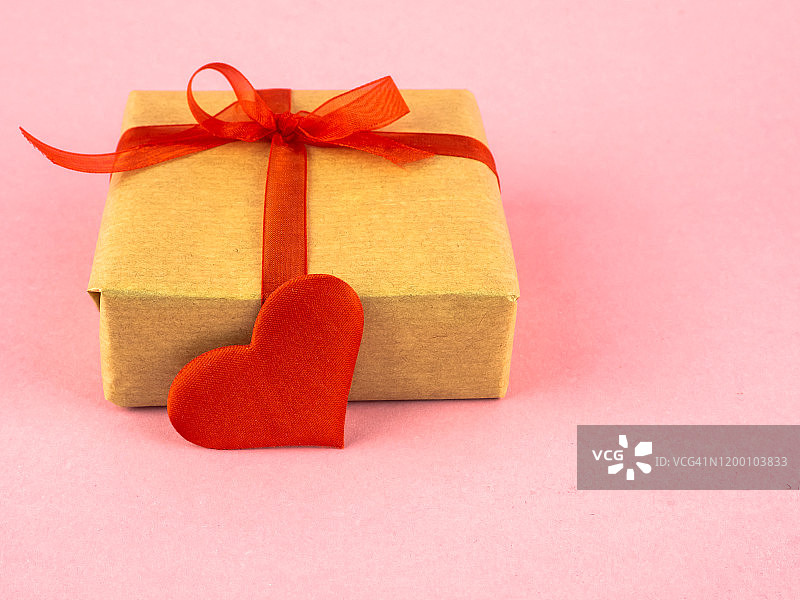 爱情与浪漫主义概念，带丝带和红色蝴蝶结的礼品包装盒，以及一颗红心图片素材
