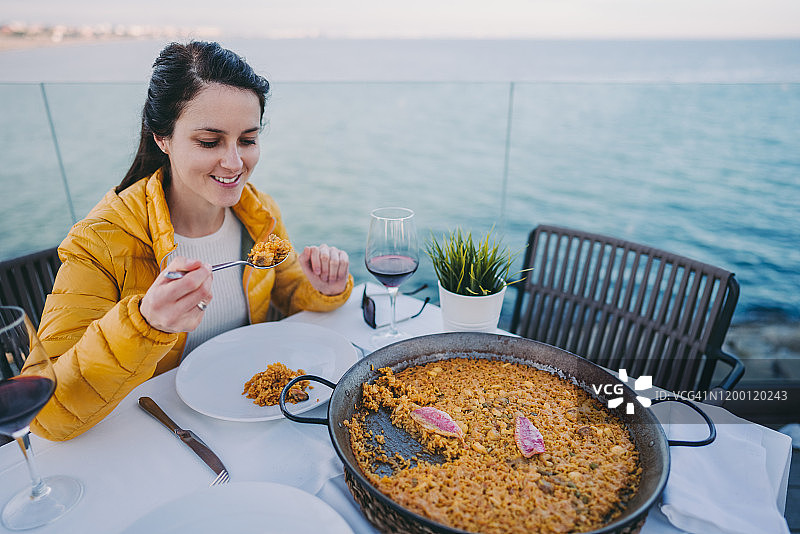 在海滩上享用西班牙海鲜饭的游客图片素材