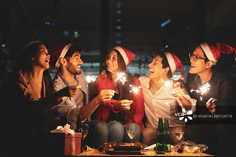 商务人士庆祝圣诞新年，手持烟花，举杯香槟图片素材