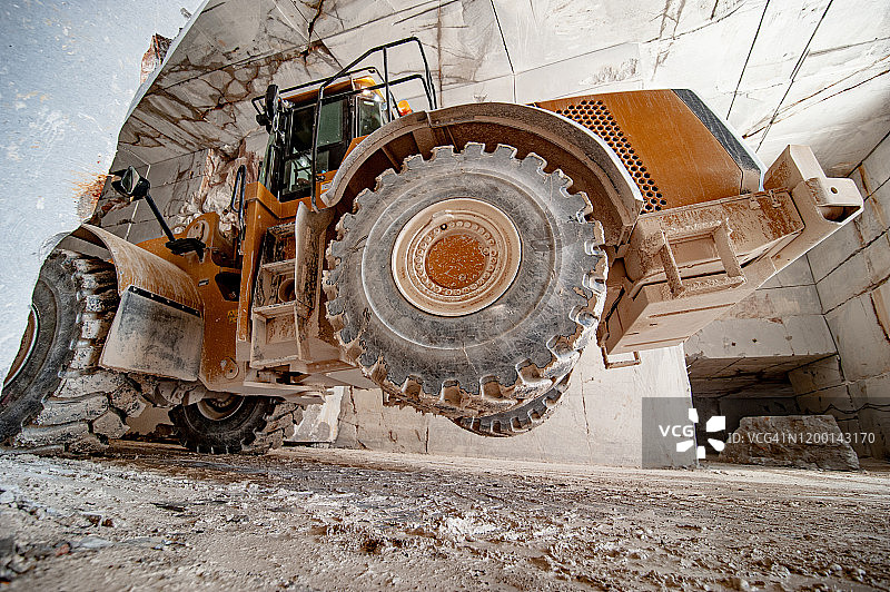 采石场中试图抬起大理石块的推土机图片素材