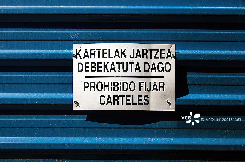 巴斯克语和西班牙语“禁止张贴海报”警告标志图片素材