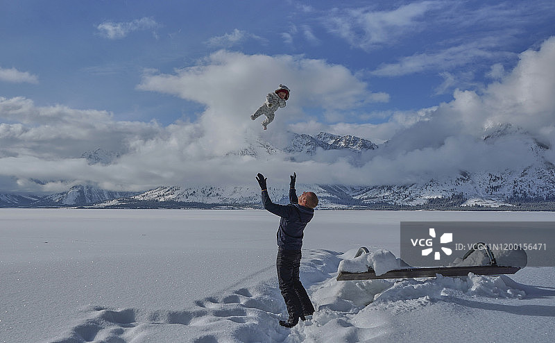 父女在杰克逊湖的圣诞节冬季玩耍，位于美国大提顿国家公园和黄石国家公园图片素材