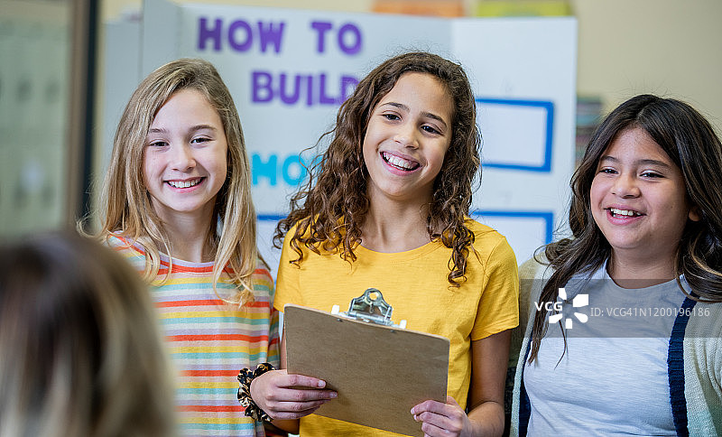 学生在科学展览会上微笑图片素材