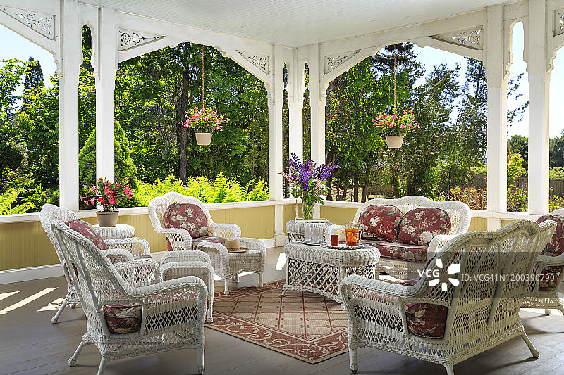 带藤制家具和周围花园的房屋前廊图片素材