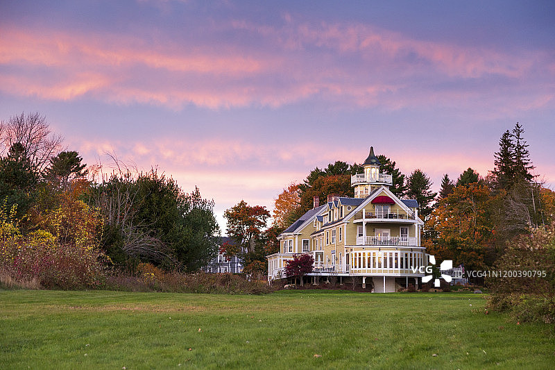维多利亚式住宅的日落外观，周围环绕着花园图片素材