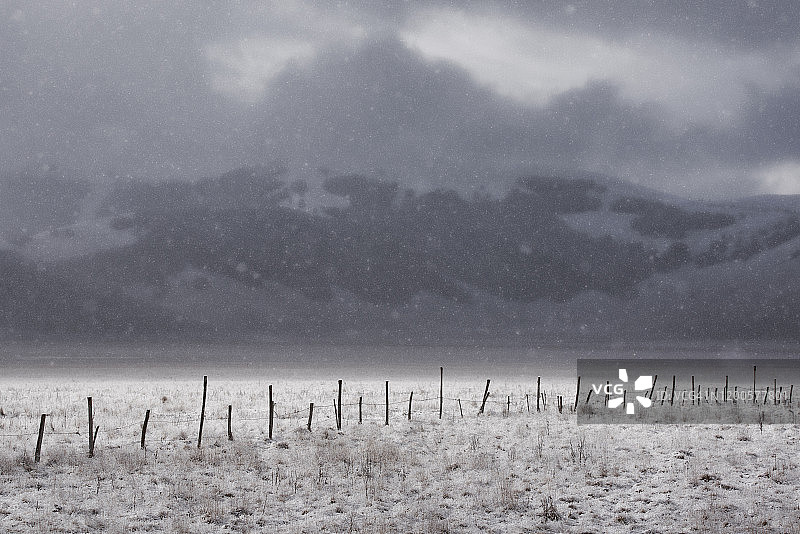 雪下高原上损坏的木栅栏图片素材