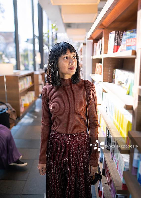 成功的亚洲女人在图书馆看书图片素材