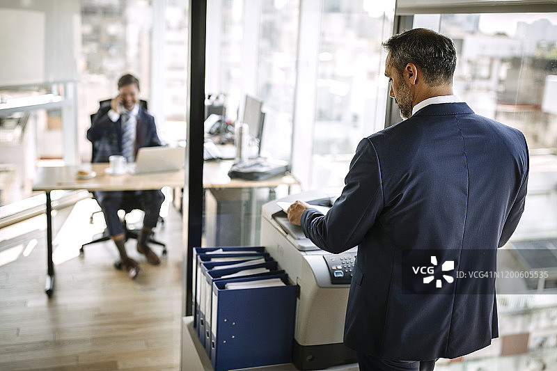 在办公室打印文件的商人图片素材