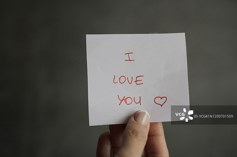 手持写有“我爱你”信息的纸张图片素材
