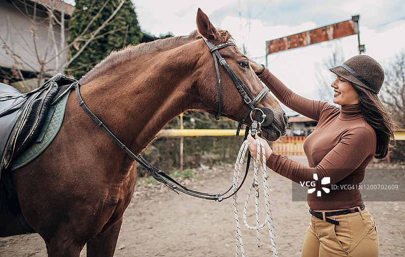年轻女骑师准备骑马图片素材