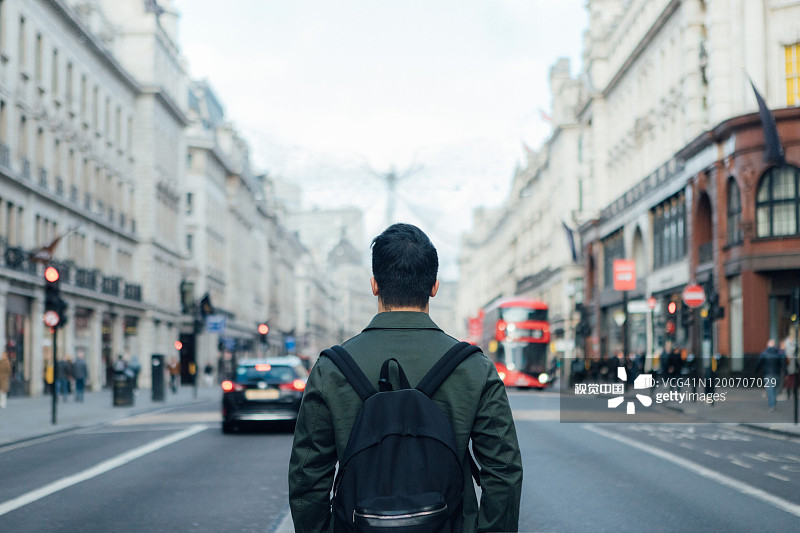 男人背影，在伦敦商业街等待优步图片素材