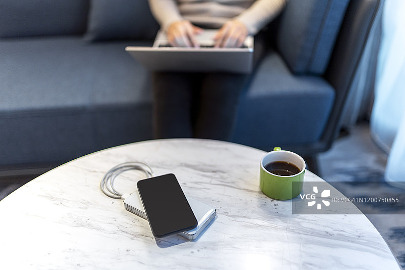 商务女士坐在沙发上使用笔记本电脑图片素材