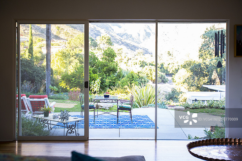 透过客厅大窗户看到的室外露台，背景是山坡图片素材