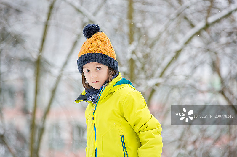 在操场上玩雪的可爱学龄前男孩图片素材