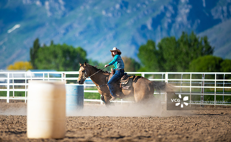 骑马绕桶赛的牛仔女郎图片素材