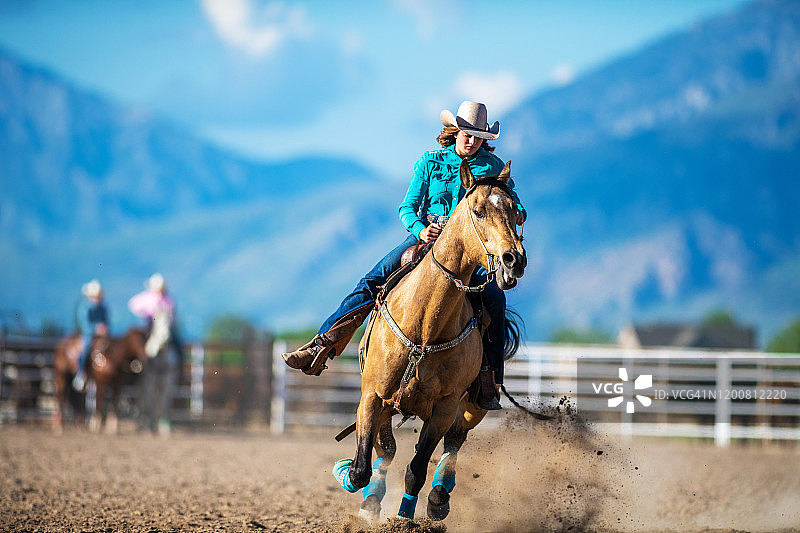骑马绕桶赛的牛仔女郎图片素材