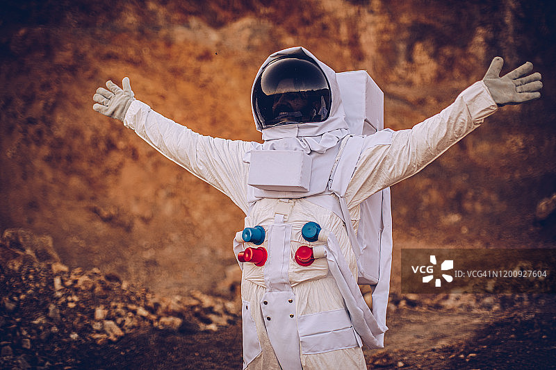 男人宇航员在火星上伸开双臂图片素材