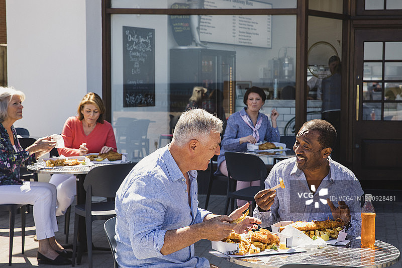 年长的男人们在咖啡馆外享用炸鱼薯条图片素材