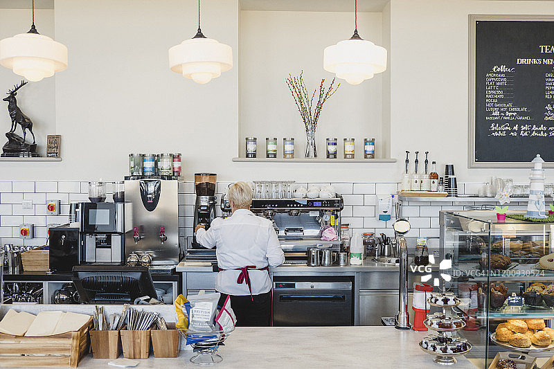 女人在咖啡馆柜台后工作背影图片素材