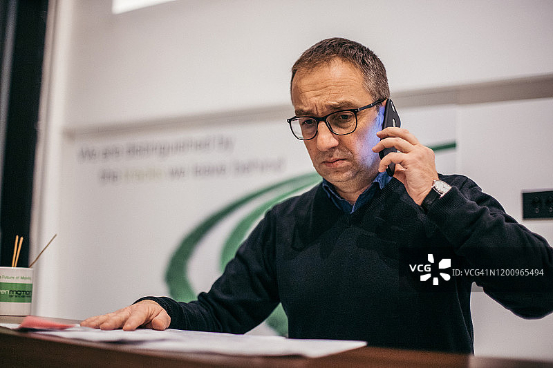 严肃的商人在办公室打电话图片素材