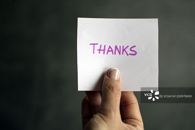 手持写有“感谢”信息的纸张图片素材