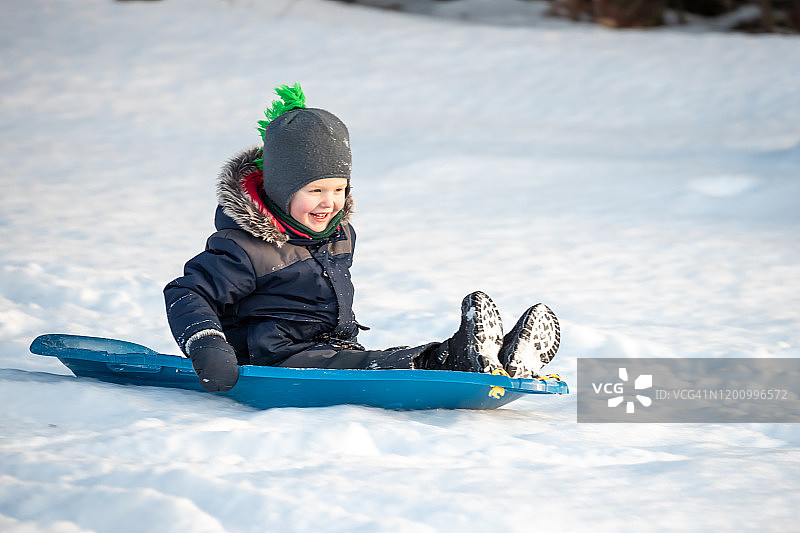 在冬日日落时分滑雪的小男孩图片素材