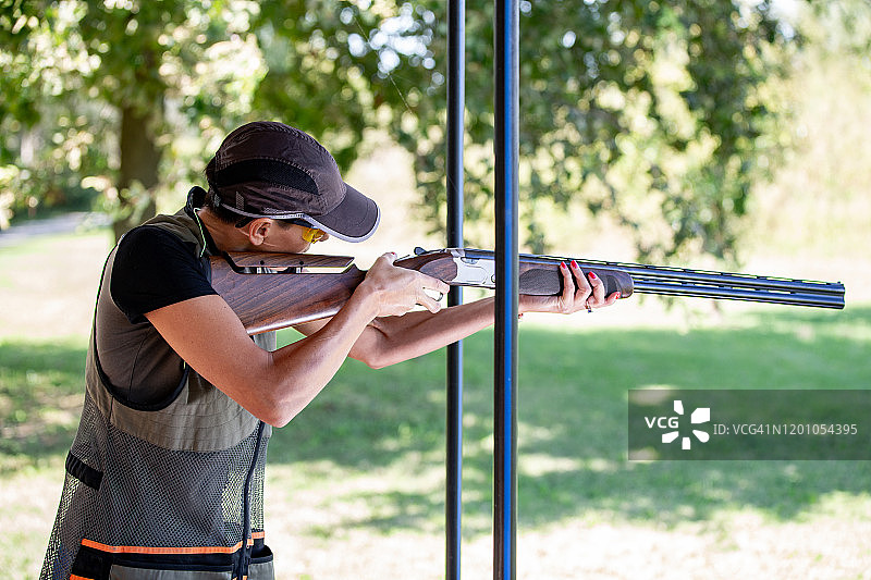 成年女性射手在飞碟射击比赛中用步枪瞄准图片素材