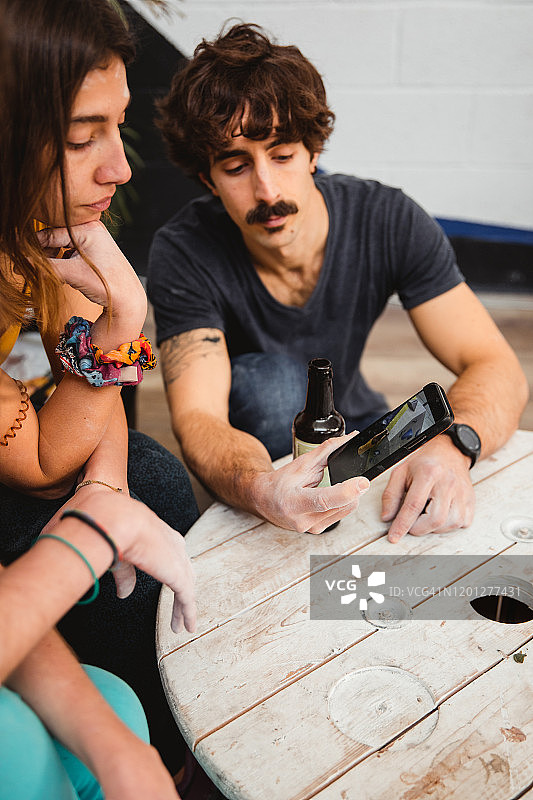 一群年轻放松的运动员在手机上看攀岩视频图片素材