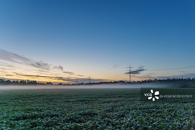 德国乡村田野薄雾笼罩下的橘蓝色金色黄昏图片素材