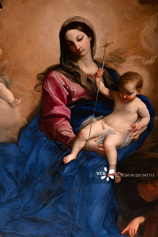 圣母玛利亚怀抱小耶稣，手持十字架，俯瞰云层图片素材