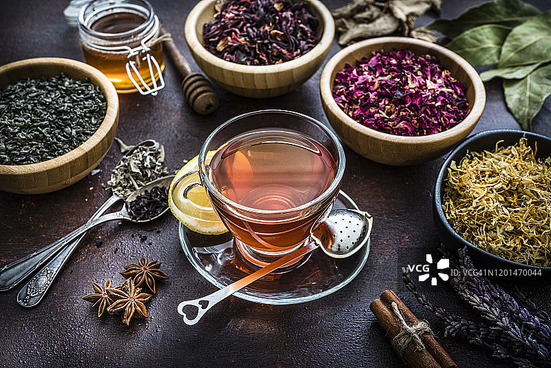 棕色桌子上俯视拍摄的茶叶与花草茶杯图片素材