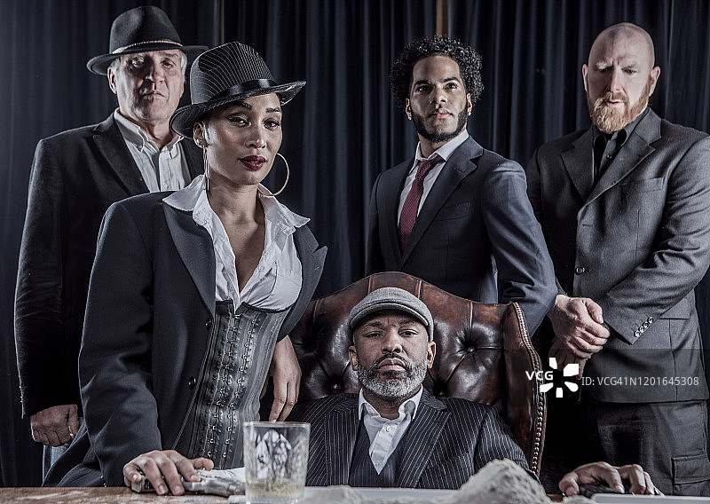 坐在豪华椅子上的黑帮男人与其他团伙成员图片素材