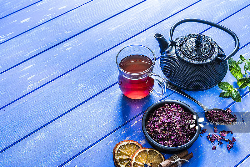 蓝色桌子上的玫瑰花瓣茶，留白图片素材