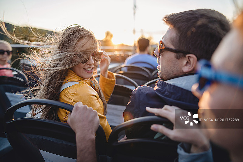 乘坐旅游巴士回头看的头发蓬乱的年轻女子图片素材