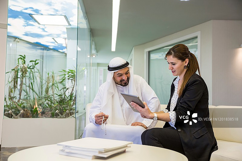 女商人向阿拉伯商人展示商业计划书图片素材